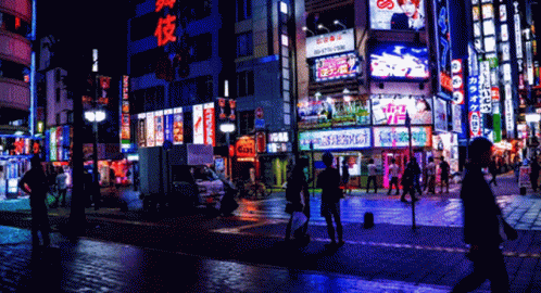 a busy city street at night with a sign that says ' tokyo ' on it