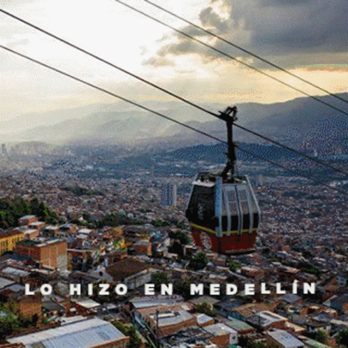 A Cable Car Going Over A City With The Words Lohizo En Medellin Written Below It GIF