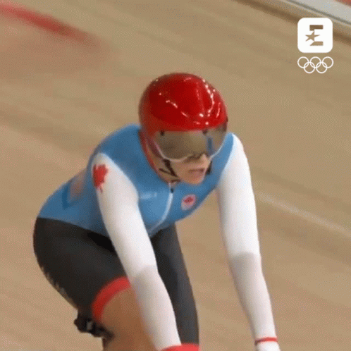 A Canadian Athlete Wearing A Red Helmet And Goggles Is Riding A Bike GIF