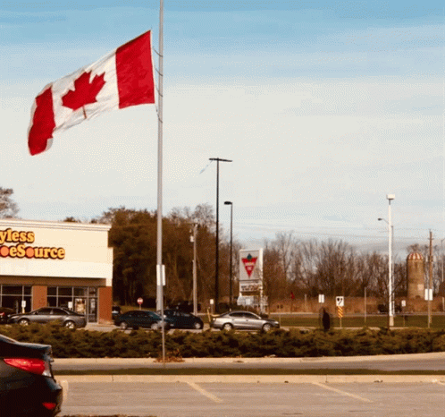 a canadian flag is flying in front of a store called styles source