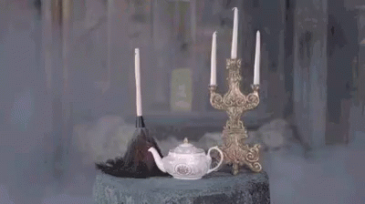 A Candle Is Being Lit In A Room With Smoke Coming Out Of It And A Candle Holder . GIF
