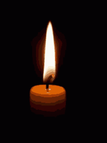 a candle is lit up in the dark and has a single flame