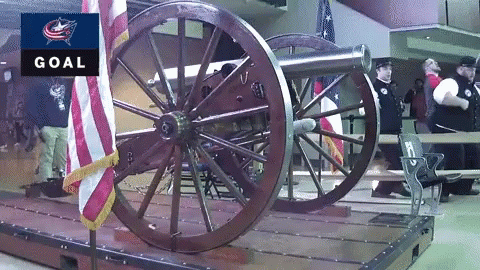 A Cannon Is On Display In Front Of An American Flag And A Goal Sign GIF