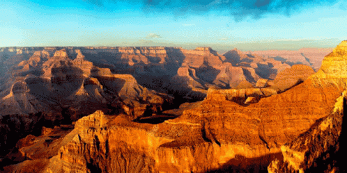 A Canyon With A Blue Sky And A Few Clouds GIF