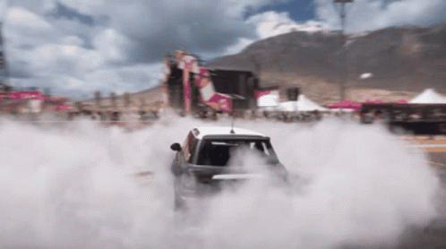 A Car Is Doing A Burnout On A Race Track GIF