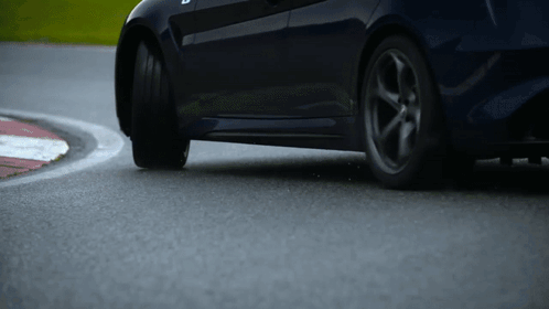 A Car Is Driving Around A Curve On A Race Track GIF