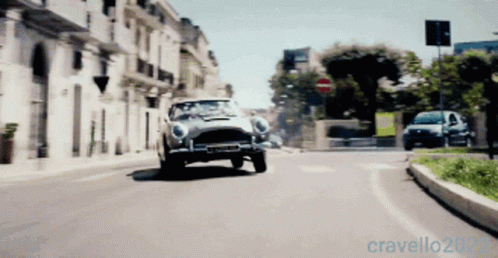 A Car Is Driving Down A City Street With The Year 2022 On The Bottom Right GIF