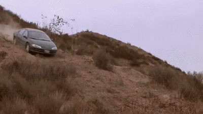 A Car Is Driving Down A Dirt Hill With A License Plate That Says ' Jc ' GIF