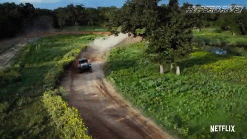 A Car Is Driving Down A Dirt Road With Netflix On The Bottom GIF