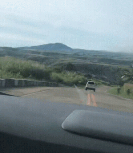 A Car Is Driving Down A Road In The Mountains GIF