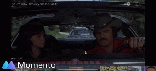 A Car Is Driving Down A Road With A Momento Logo In The Background GIF