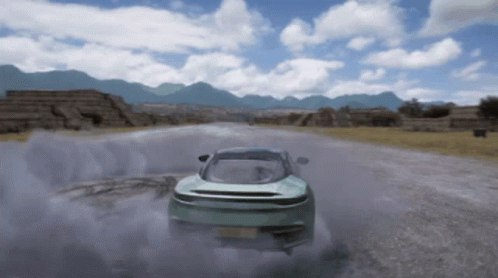 A Car Is Driving Down A Road With Mountains In The Background And Smoke Coming Out Of It GIF