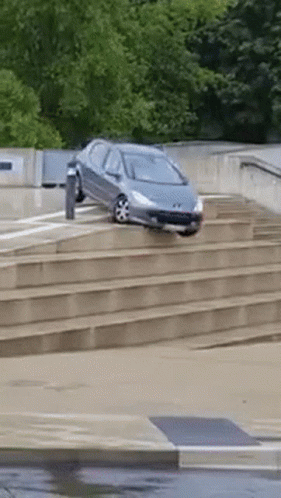 A Car Is Driving Down A Set Of Steps GIF