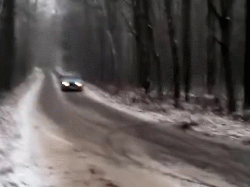 A Car Is Driving Down A Snow Covered Road GIF
