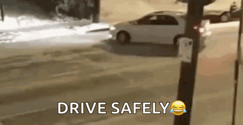 A Car Is Driving Down A Snowy Street With The Words `` Drive Safely '' Written On The Bottom . GIF