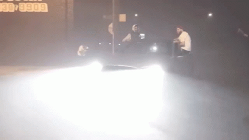 A Car Is Driving Down A Street At Night With A Sign In The Background That Says 30 5900 GIF