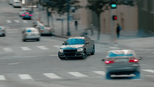 A Car Is Driving Down A Street With A Red Light GIF