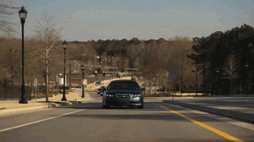 A Car Is Driving Down A Street With A Yellow Line GIF
