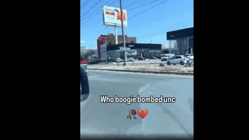 A Car Is Driving Down A Street With The Words Who Boogie Bombed Unc Written On The Windshield GIF