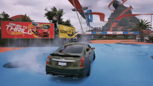 A Car Is Driving In Front Of A Hot Wheels Sign GIF