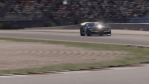 A Car Is Driving On A Race Track With A Crowd Watching GIF