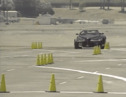 A Car Is Driving Through A Parking Lot With Yellow Cones GIF