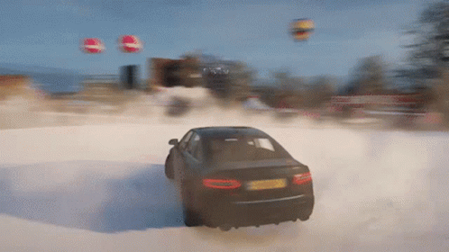 A Car Is Driving Through A Snowy Field With Balloons Flying In The Background GIF