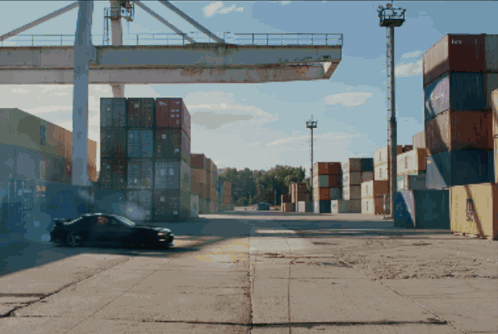 a car is driving through a warehouse with containers stacked on top of each other and one of the containers says aa