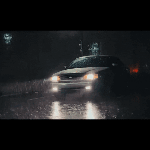A Car Is Driving Through The Rain At Night GIF