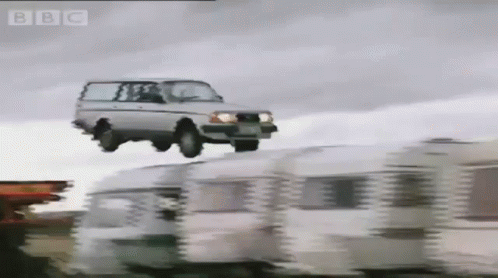 A Car Is Flying Over A Row Of Caravans With The Bbc Logo In The Corner GIF