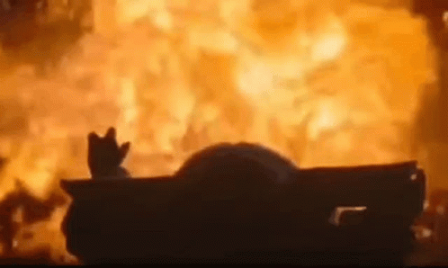A Car Is On Fire With A Hand Sticking Out Of The Window . GIF
