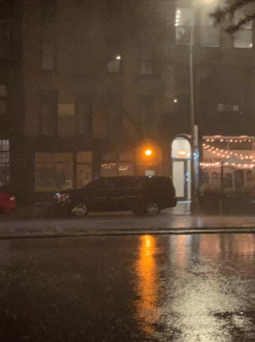 A Car Is Parked On The Side Of The Road In Front Of A Building GIF