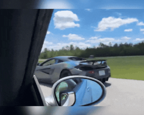 A Car Is Parked On The Side Of The Road With A Rear View Mirror GIF