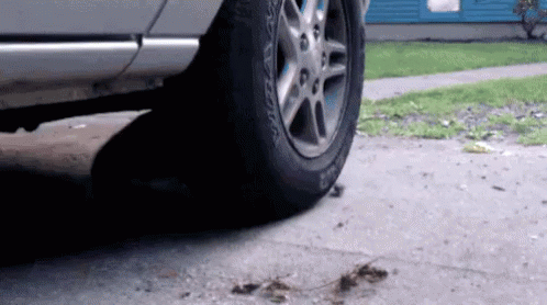 A Car With A Tire That Says Bfgoodrich On It Is Parked On The Sidewalk . GIF
