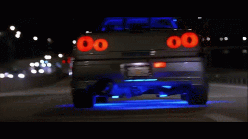A Car With The Number 00 On The Back Is Driving Down The Road GIF