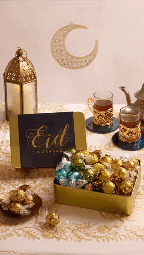 A Card That Says Eid Mubarak Sits Next To A Box Of Chocolates GIF