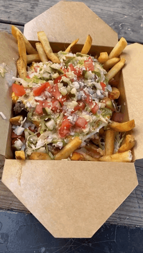 A Cardboard Box Filled With French Fries And Vegetables GIF