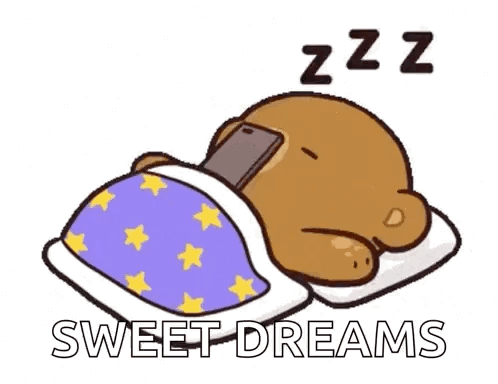 A Cartoon Bear Is Sleeping In A Bed With A Cell Phone In Its Paws . GIF