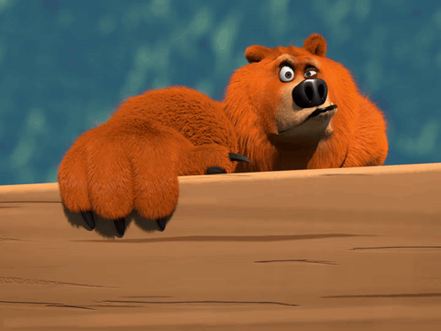 A Cartoon Bear Laying On A Wooden Table GIF
