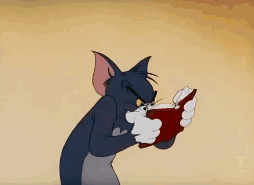 A Cartoon Cat Is Reading A Book With A Very Angry Look On His Face GIF