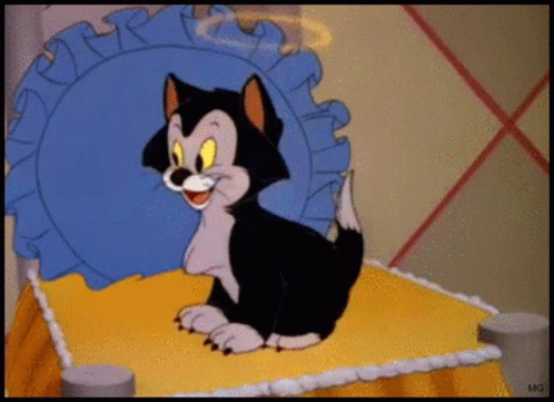 A Cartoon Cat Is Sitting On A Bed With A Blue Pillow Behind Him GIF