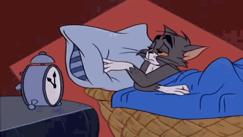 A Cartoon Cat Is Sleeping In A Bed Next To An Alarm Clock GIF