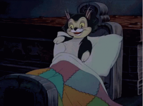 A Cartoon Cat Is Sleeping In A Chair With A Blanket GIF