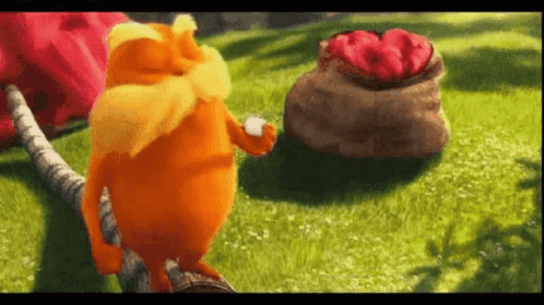 A Cartoon Cat Is Standing On A Tree Branch In The Grass Next To A Bag Of Strawberries . GIF