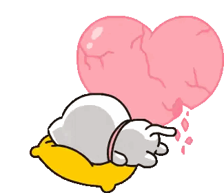 a cartoon cat laying on a yellow pillow with a broken heart behind it