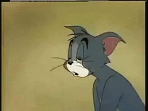 A Cartoon Cat Named Tom Is Sitting Down And Looking At Something GIF
