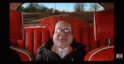 A Cartoon Character In A Car With A Red Hat On GIF