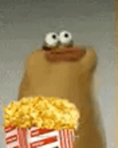 A Cartoon Character Is Holding A Bag Of Popcorn With Big Eyes . GIF