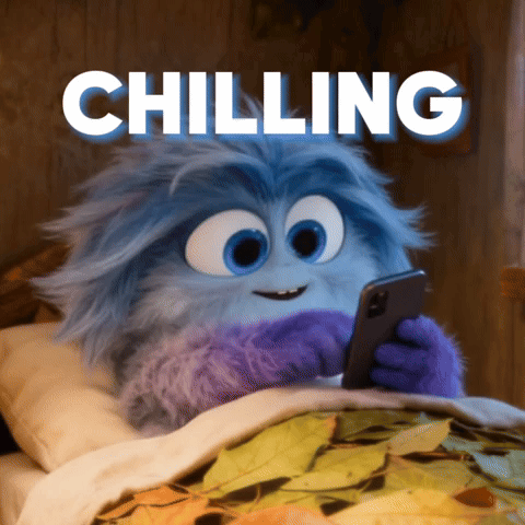 A Cartoon Character Is Laying In Bed Looking At A Cell Phone With The Words Chilling Above Him GIF