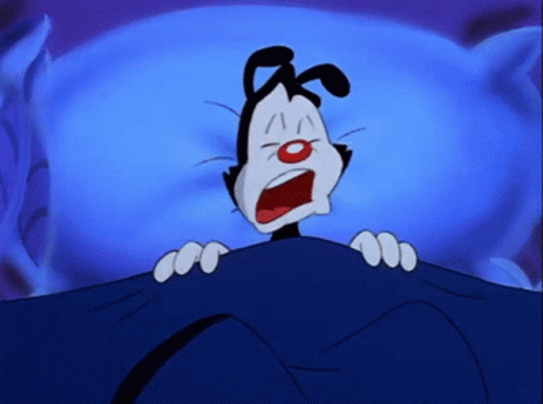A Cartoon Character Is Laying Under A Blue Blanket GIF